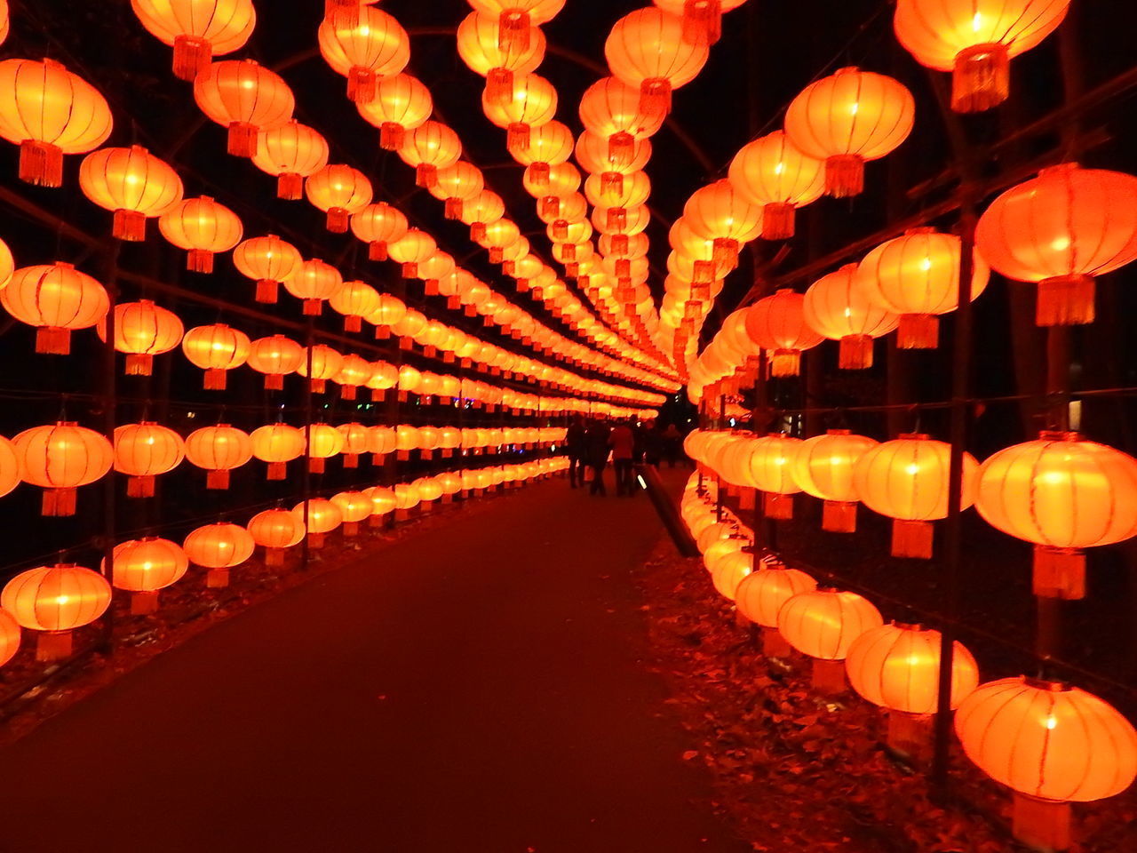 ILLUMINATED LANTERNS HANGING IN ROW AT NIGHT DURING CHRISTMAS