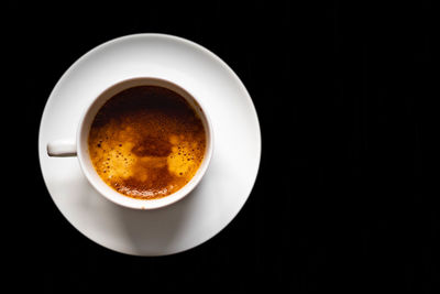 Directly above shot of coffee cup against black background