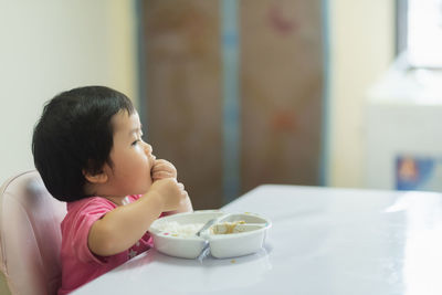 Cute boy eating food at home