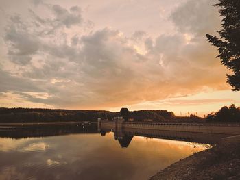 Scenic view of river against sky at sunset