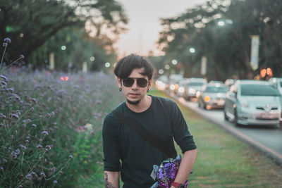 Portrait of young man standing in city