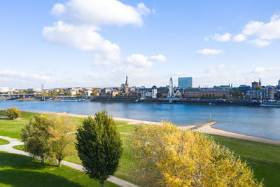 Scenic view of river by buildings against sky