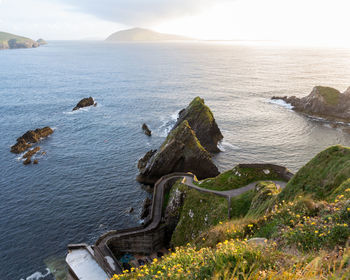 Scenic view of cliff by sea against sky