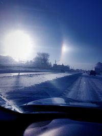 Sun shining through clouds over road