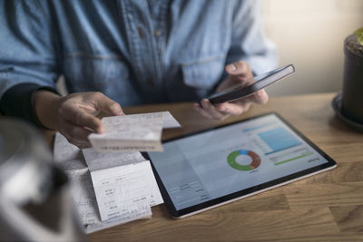 Woman organizing household budget with digital tablet