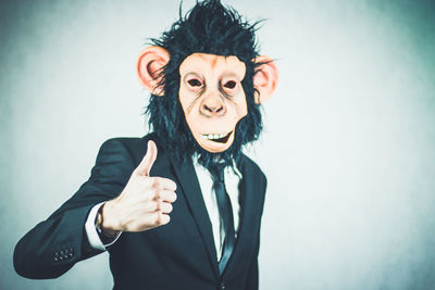 Man wearing monkey mask against white background