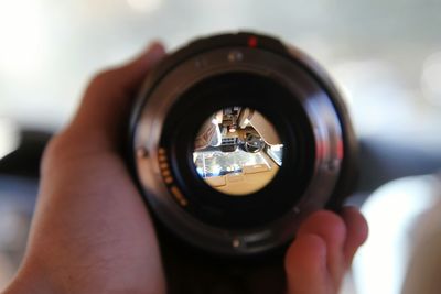 Cropped hand holding camera in car