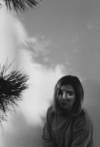 Portrait of woman standing against wall