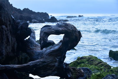 Rocks on sea shore against sky