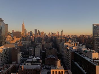 Aerial view of buildings in city against clear sky