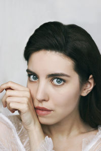 Close-up portrait of a young woman over white background