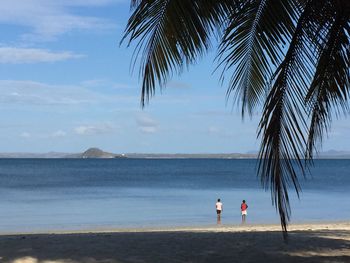 People at beach against sky