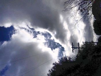 Low angle view of silhouette trees against sky