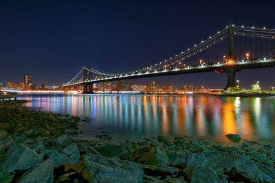 Suspension bridge over river at night