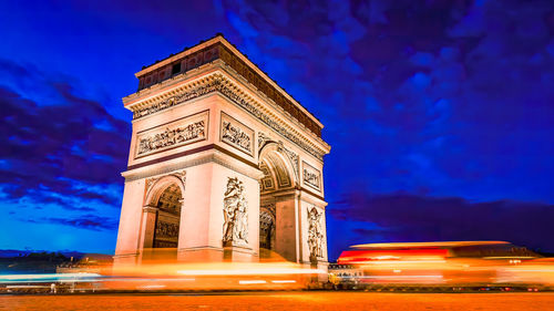 Champs-elysees and arc de triomphe at night in paris, france. architecture and landmarks of paris.