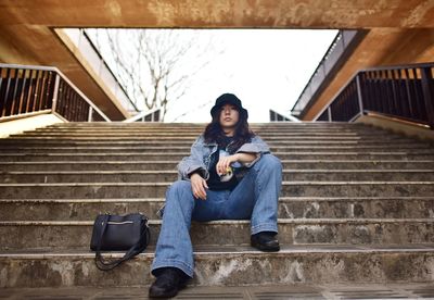 Low angle view of woman sitting on staircase