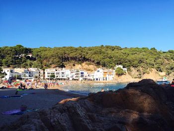 Houses by sea against clear sky