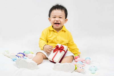 Portrait of cute girl playing with toys against white background