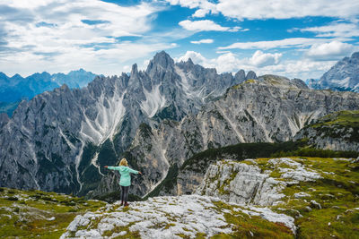 Aerial view of a woman hiker admiring cadini di misurina mountain. italian alps, dolomites