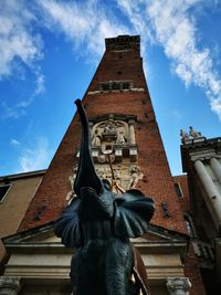 Low angle view of statue against building against sky