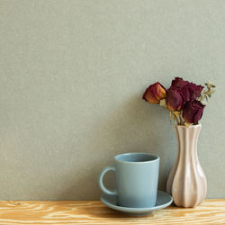 Coffee cup on table against wall