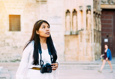 Young woman looking away in city