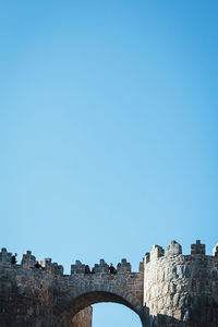 Low angle view of built structure against clear blue sky