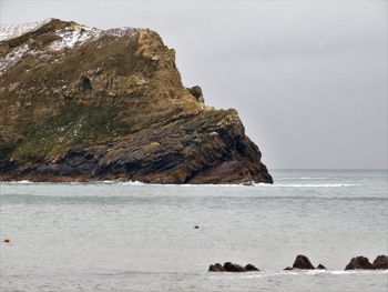 Rocks on sea shore against sky