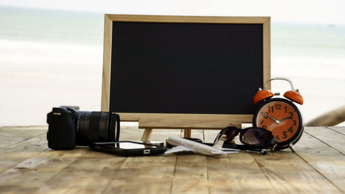 Close-up of technologies with black board on table