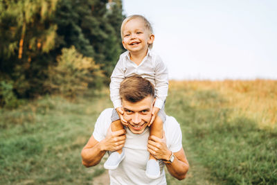 Portrait of happy mother and son on man