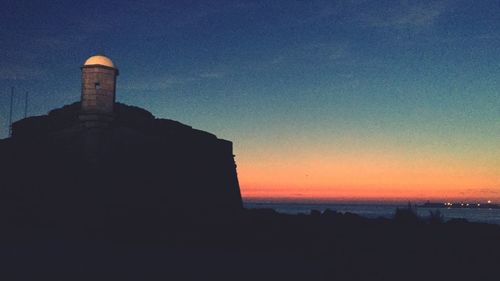 Silhouette built structure against sky during sunset