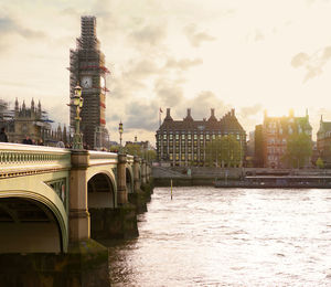 Arch bridge over river against buildings in city