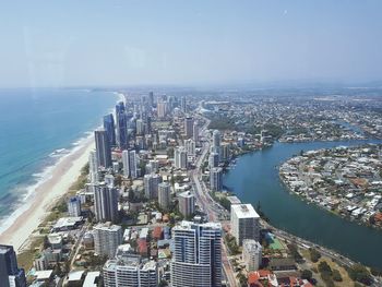 High angle view of city by sea against sky