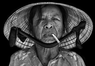 Portrait of man wearing hat against black background