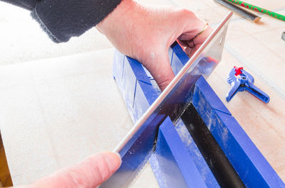 Cropped image of man cutting metal in workshop