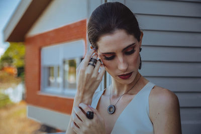 Portrait of young woman looking down outdoors