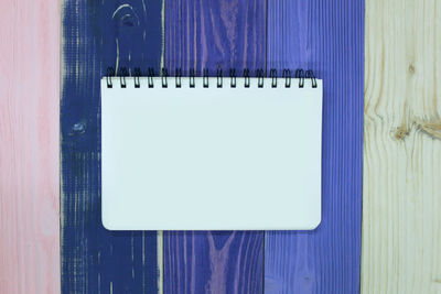 Directly above shot of paper on table against white wall