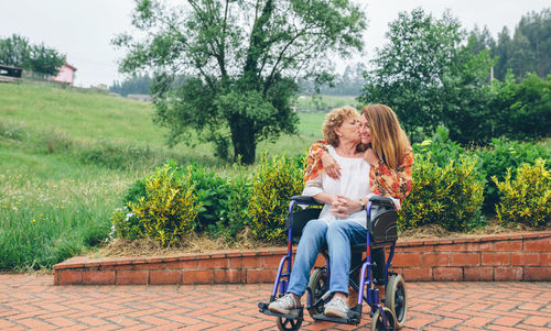 Full length of smiling woman sitting in park