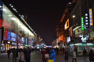 People walking in city at night