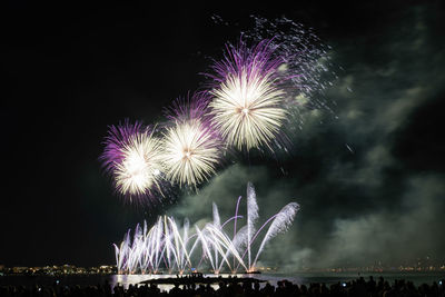 Low angle view of firework display at night