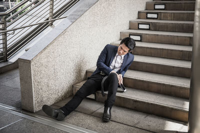 Worried businessman sitting steps