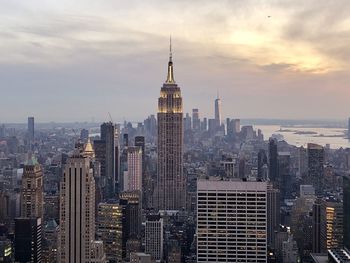 Modern buildings in city against cloudy sky