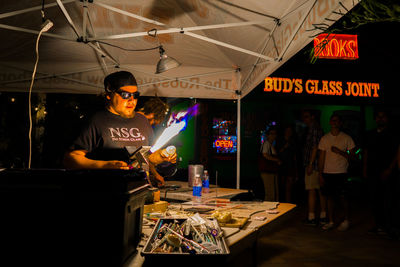 Side view of people holding display at night