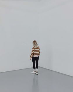 Rear view of woman standing against white background