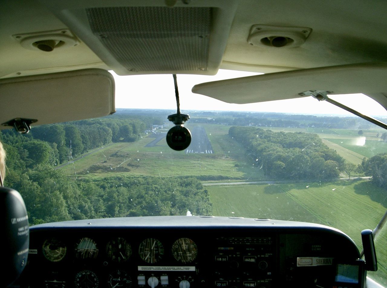 VIEW OF AIRPLANE SEEN THROUGH WINDOW OF CAR