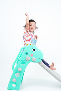 Portrait of young woman holding toy against white background
