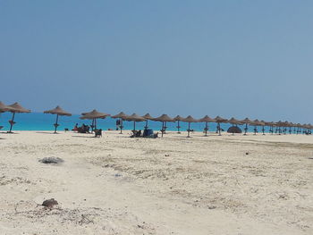 Scenic view of beach against clear blue sky