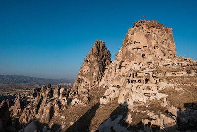 Panoramic view of rocky mountains against clear blue sky