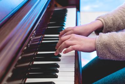 Midsection of woman playing piano