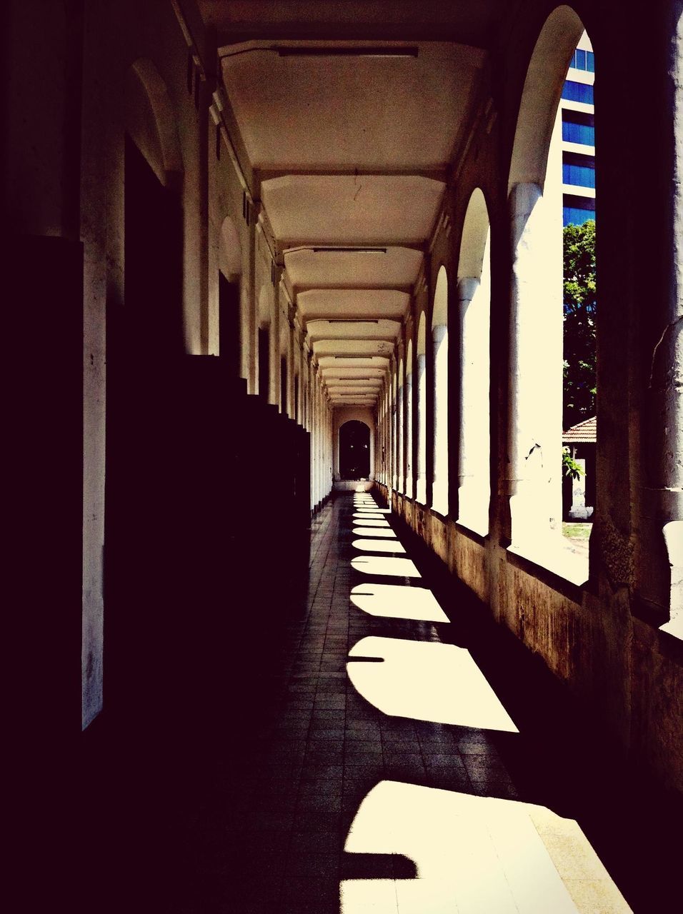 architecture, indoors, built structure, the way forward, diminishing perspective, corridor, arch, in a row, narrow, architectural column, empty, vanishing point, building, ceiling, long, column, colonnade, tunnel, sunlight, absence